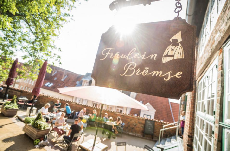 Toeristen en locals die aan het genieten zijn van een kop koffie bij Café Fräulein Brömse