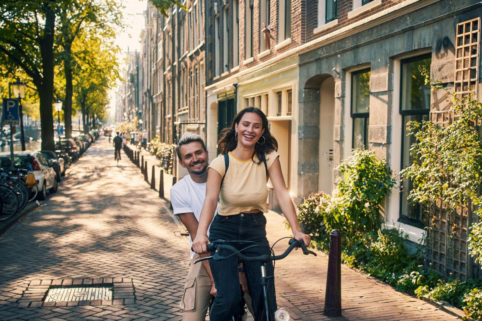 Fiets of wandel over de prachtige grachten van Amsterdam | iStock - pixdeluxe
