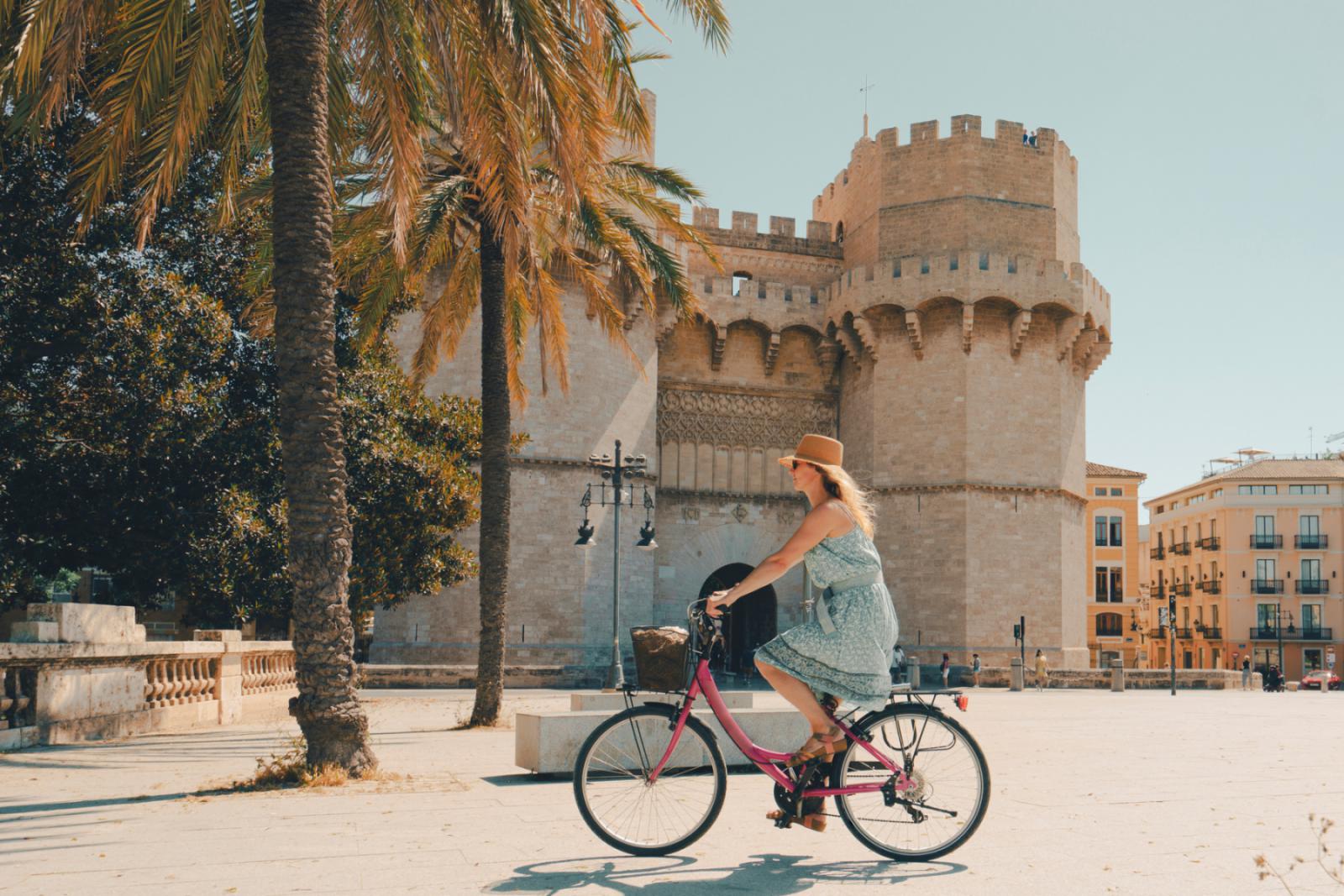 Vrouw op de fiets in de Stad Valencia voor een monument