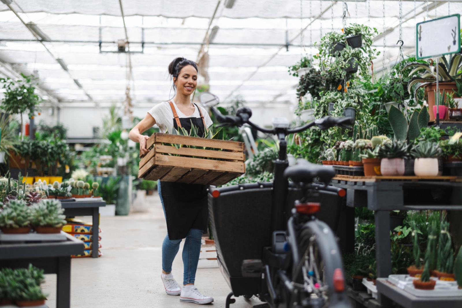 Vrouw laadt bloemen in de bakfiets